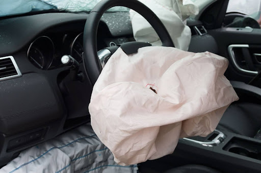Crash impact image of a car with airbags fully deployed for occupant safety.