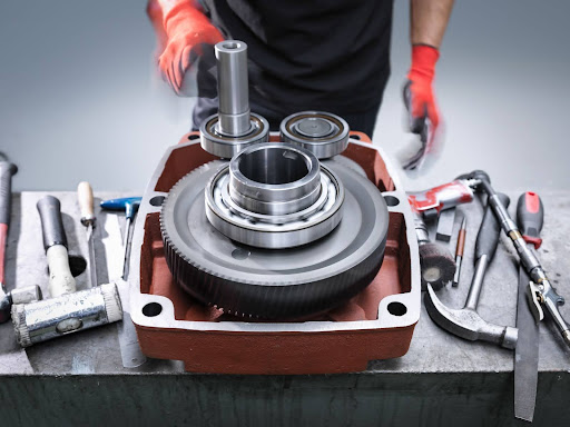 Cropped shot of a male engineer assembling an industrial car gearbox in a factory.